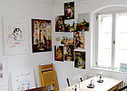Innenraum mit Fenster und langem Holztisch und Bildern an der Wand