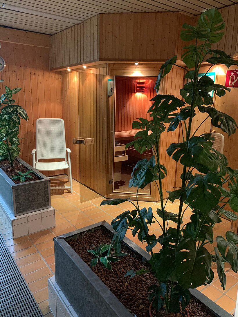 Hallenbad Arnstein Ruheraum mit Blumen im zwei länglichen Trögen und weißem Ruhestuhl