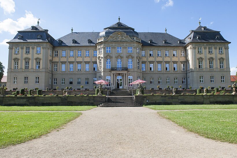 Schloss Werneck / Foto: Florian Trykowski Barocke Schlossanlage mit breitem Weg in der Mitte Richtung Eingang und grünem Rasen beidseits