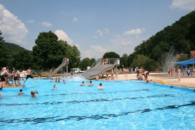 Gemünden Freibad Freibadszene mit schwimmenden und spielenden Besuchern in und am Wasser