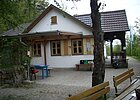 Haus mit Baum und Bänken davor