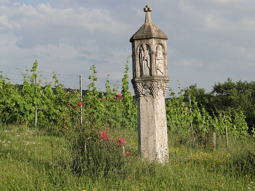Weinberg First in Eußenheim/Foto: Kerstin Sewald Bildstocksäule und vier Steinskulpturen und kleinem Steindächlein oben mit Spitze. Sie steht inmitten eines Weinberges