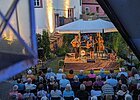 Musik in historischen Häusern und Höfen Eine Band spielt auf einer kleinen Bühne vor Publikum