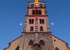 Kirchenfassade mit Turm, Eingang unter Turm, beleuchtet in Abenddämmerung
