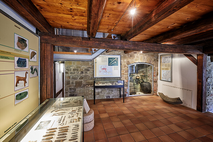 Archäologisches Museum Geldersheim Innenraum mit Holzdecke und Holzboden und präsentierten Ausstellungsstücken an der linken Wand