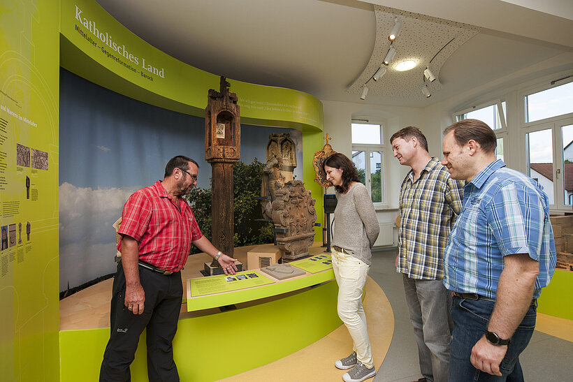 Bildstockzentrum Werneck-Egenhausen Ausstellungsraum mit Fensterseite rechts und vier Personen